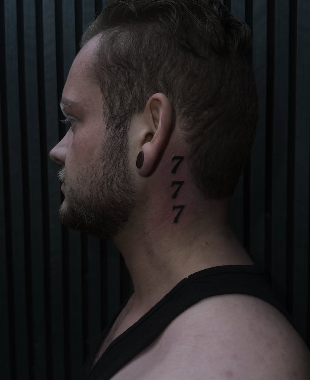 Die Zahl 777 senkrecht am Hals hinter dem Ohr