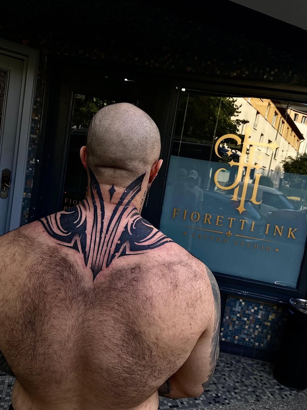 Frisch gestochenes Nacken-Tattoo, Kunde vor dem Schaufenster des Studios